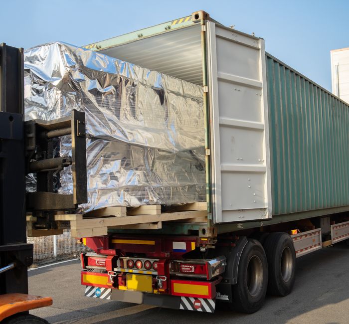 Carico merci su pallet in container su rimorchio specifico